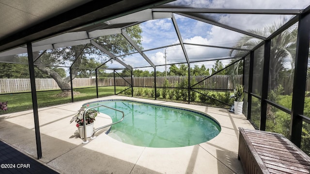 view of swimming pool featuring glass enclosure, a yard, and a patio