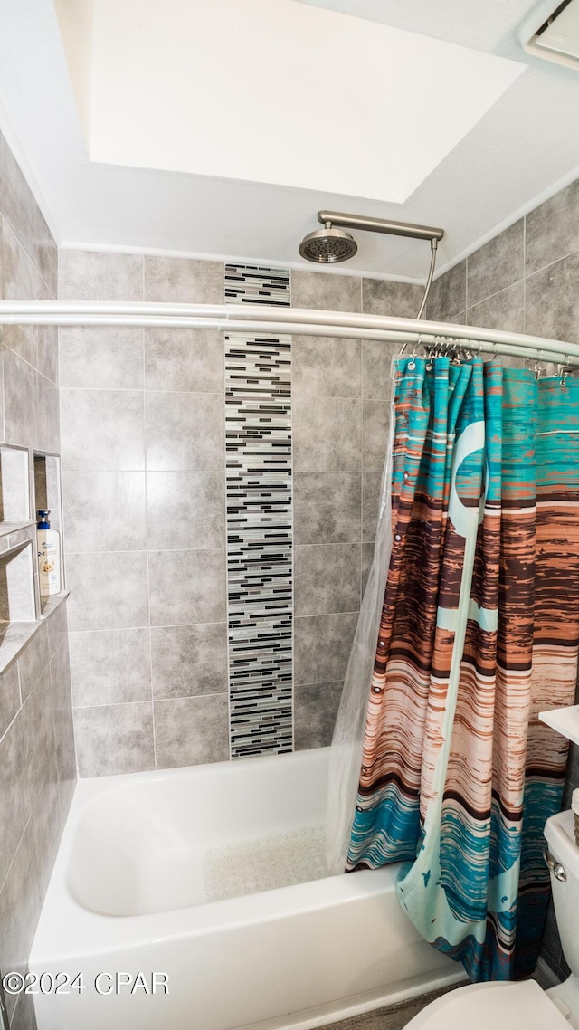 bathroom featuring toilet and shower / bath combo with shower curtain