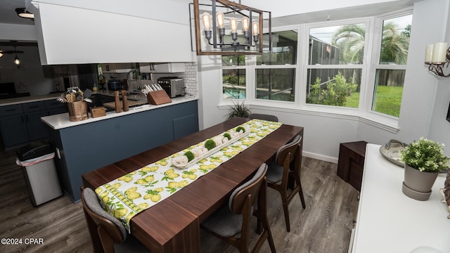 dining space with an inviting chandelier and dark wood-type flooring