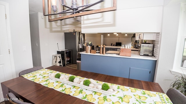 kitchen featuring kitchen peninsula and stainless steel refrigerator with ice dispenser