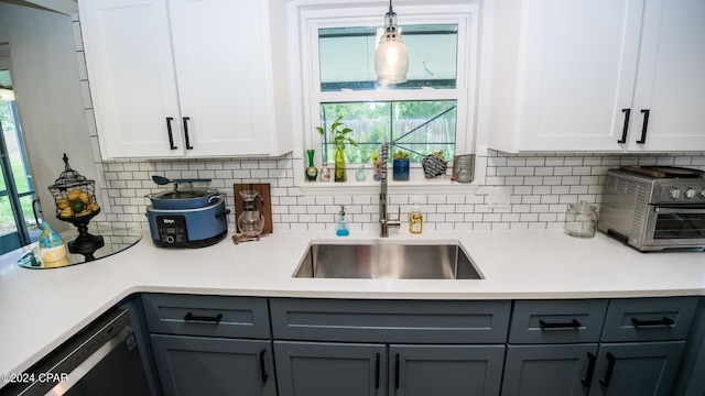 kitchen featuring gray cabinetry, sink, pendant lighting, dishwasher, and white cabinetry