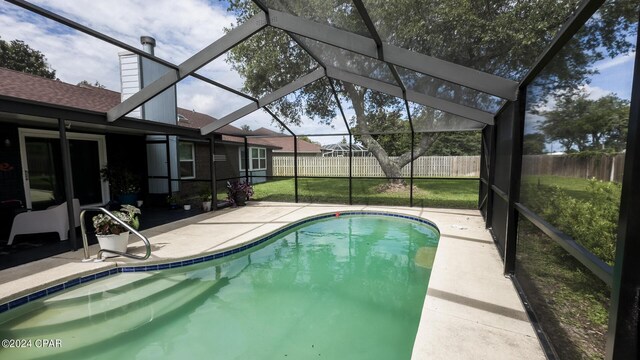 view of swimming pool with glass enclosure, a patio area, and a lawn