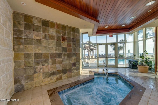 view of pool featuring an indoor hot tub and a water view