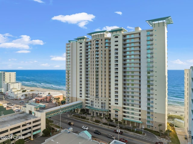 view of building exterior with a beach view and a water view