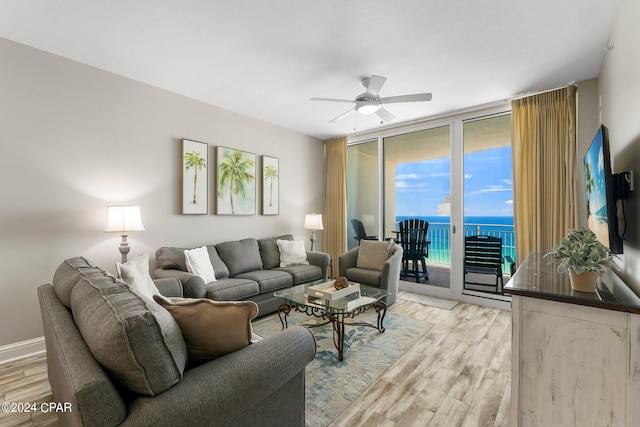 living room featuring ceiling fan, plenty of natural light, and light hardwood / wood-style floors