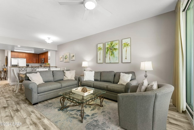 living room with light hardwood / wood-style floors and ceiling fan