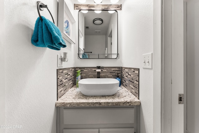 bathroom featuring vanity and tasteful backsplash