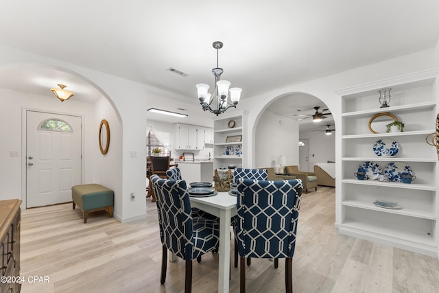 dining area with light hardwood / wood-style flooring and ceiling fan with notable chandelier