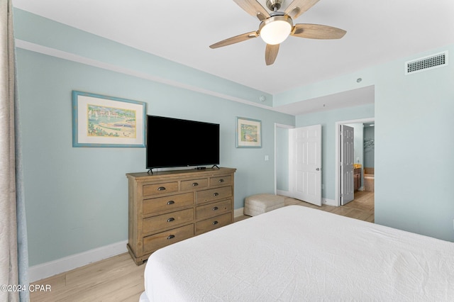 bedroom with ceiling fan, connected bathroom, and light hardwood / wood-style flooring