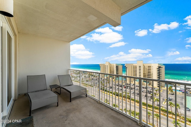 balcony featuring a water view and a view of the beach