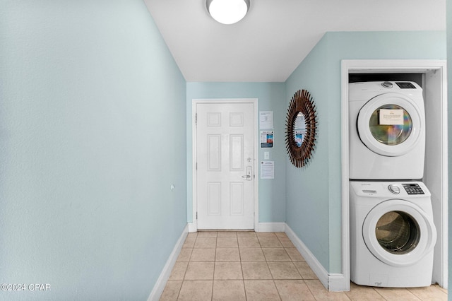 laundry room with stacked washer / drying machine and light tile patterned flooring