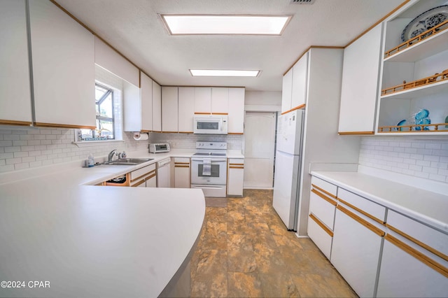 kitchen featuring tile patterned flooring, decorative backsplash, white appliances, and white cabinets