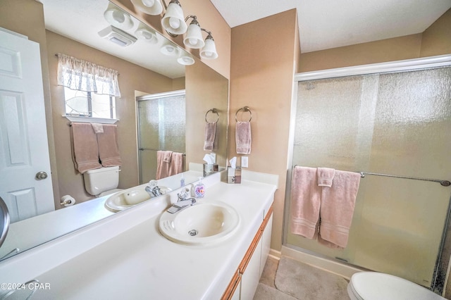 bathroom with a shower with door, vanity, tile patterned flooring, and toilet