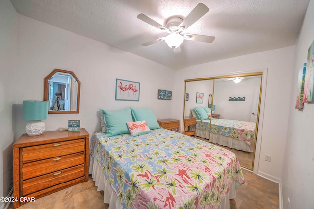 bedroom with ceiling fan, a textured ceiling, a closet, and light tile patterned floors