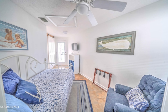 tiled bedroom featuring a textured ceiling and ceiling fan