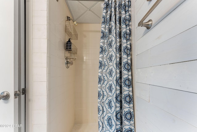 bathroom featuring wood walls and curtained shower