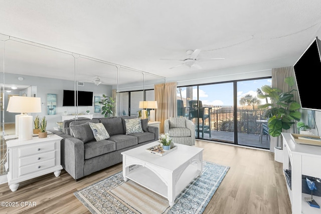 living room with ceiling fan and light wood-type flooring