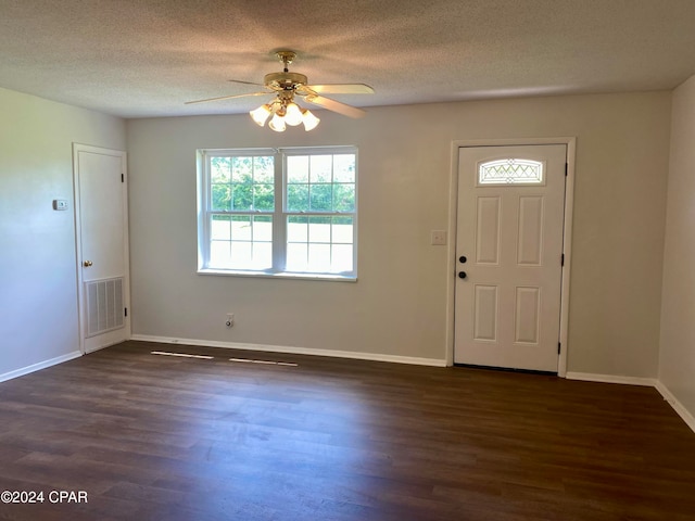 foyer entrance with ceiling fan, dark hardwood / wood-style flooring, and a textured ceiling