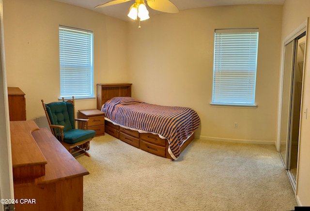 carpeted bedroom with ceiling fan and a closet