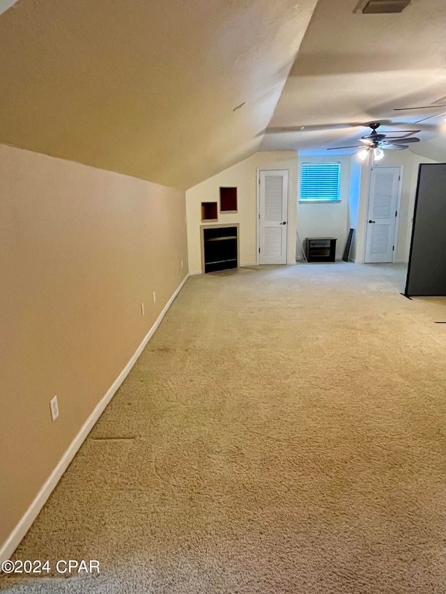 additional living space featuring ceiling fan, lofted ceiling, and carpet floors