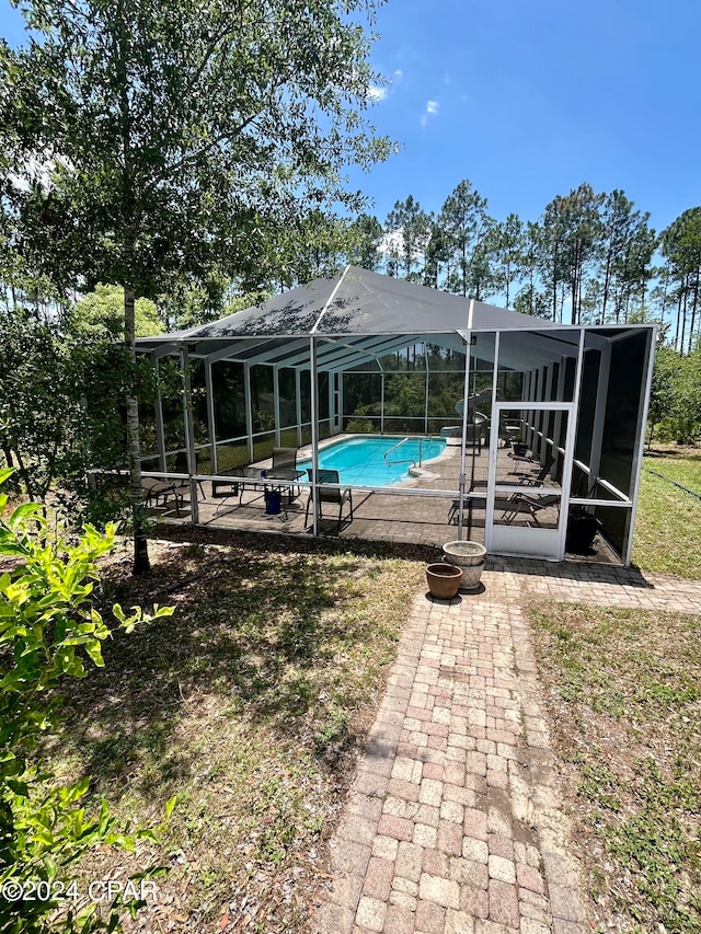 view of swimming pool with glass enclosure and a patio area