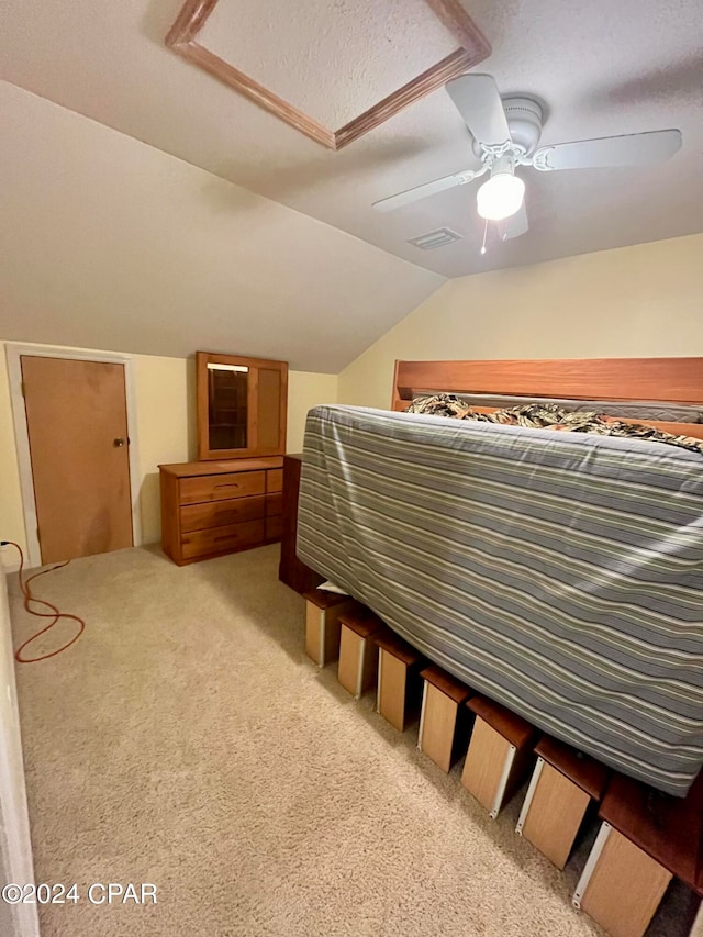 bedroom with a textured ceiling, light colored carpet, ceiling fan, and lofted ceiling