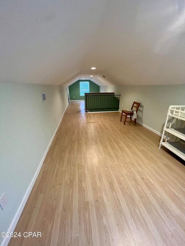 bonus room featuring vaulted ceiling and light hardwood / wood-style flooring