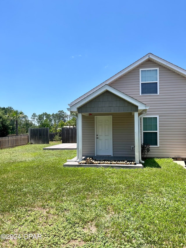 back of house featuring a lawn