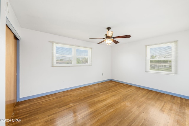 spare room with light wood-style floors, ceiling fan, and baseboards