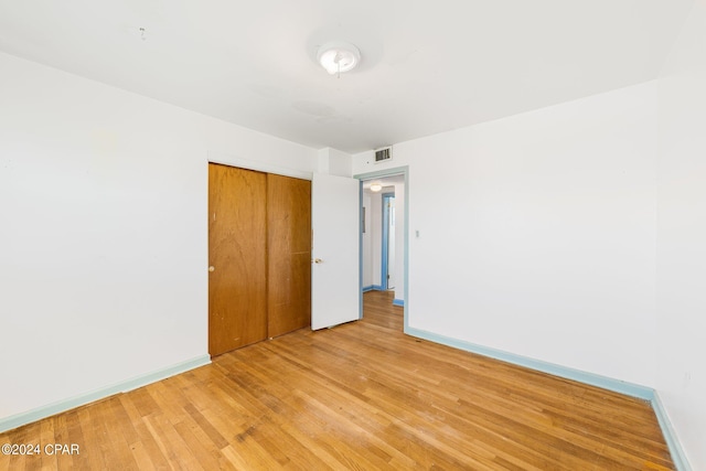 spare room with light wood-style floors, visible vents, and baseboards