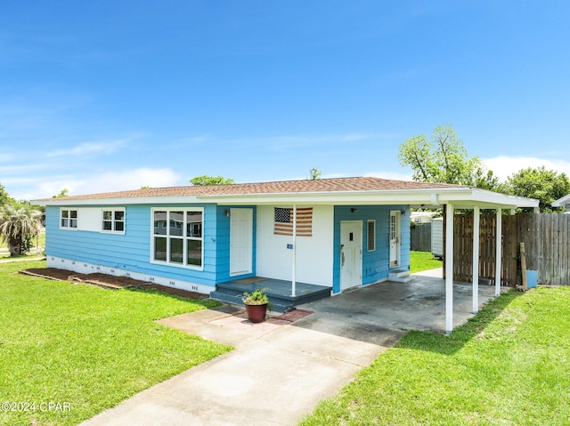 ranch-style home featuring a carport and a front lawn