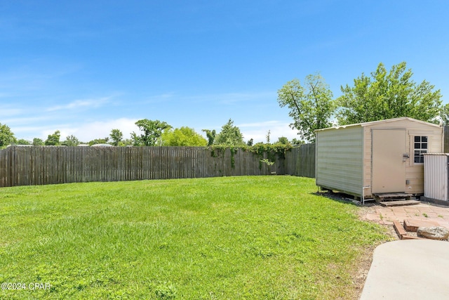 view of yard featuring an outbuilding, a storage shed, and a fenced backyard