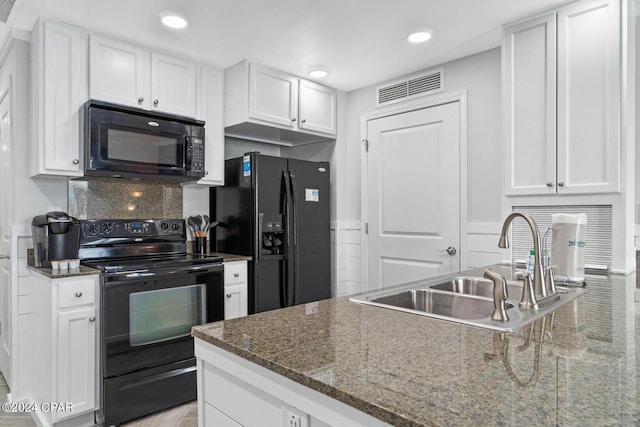 kitchen with dark stone counters, sink, white cabinets, black appliances, and backsplash