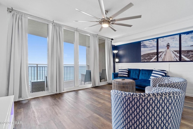 living room featuring a water view, ornamental molding, dark hardwood / wood-style floors, and ceiling fan