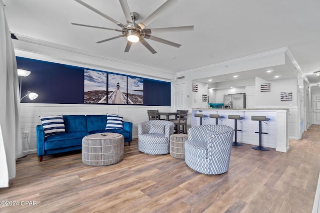 living room with crown molding, ceiling fan, and hardwood / wood-style flooring