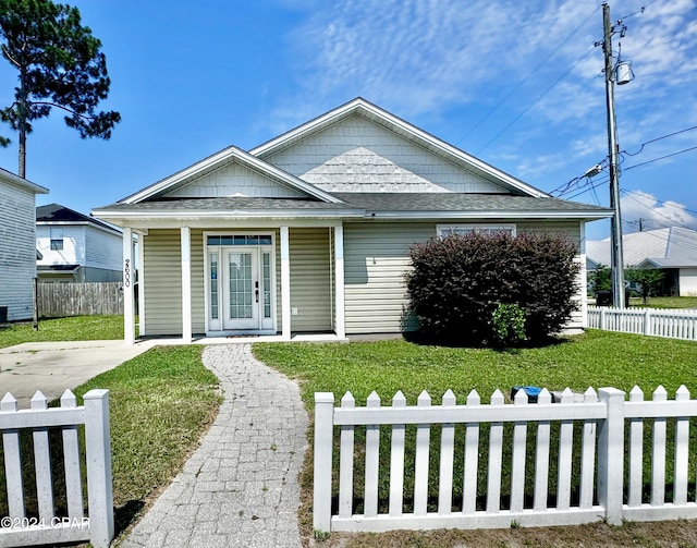 bungalow-style home with a front lawn, covered porch, and french doors