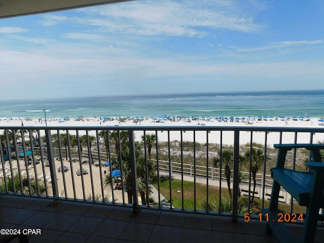 balcony featuring a water view and a beach view