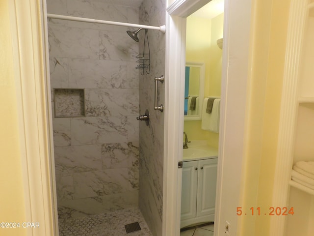 bathroom with tiled shower and sink