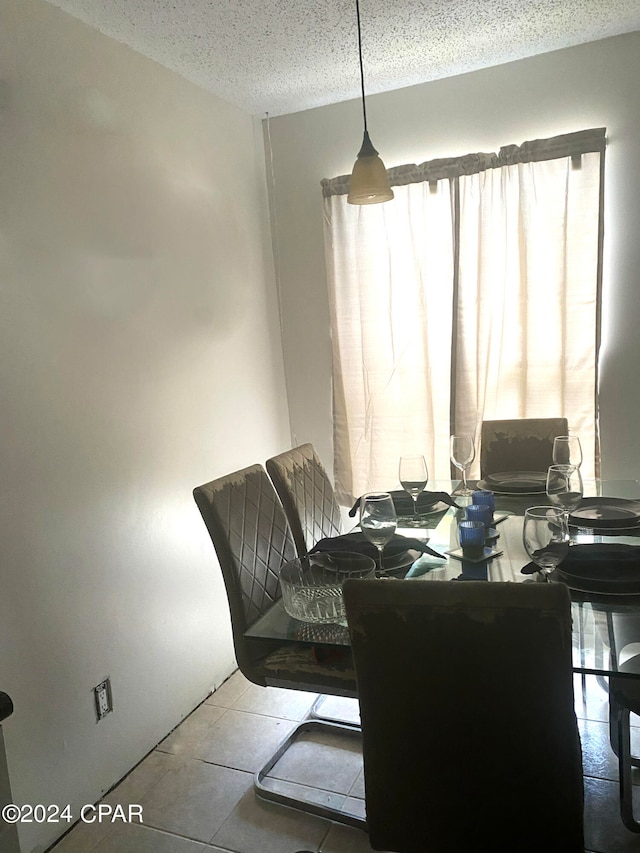 dining room featuring a textured ceiling and tile patterned flooring