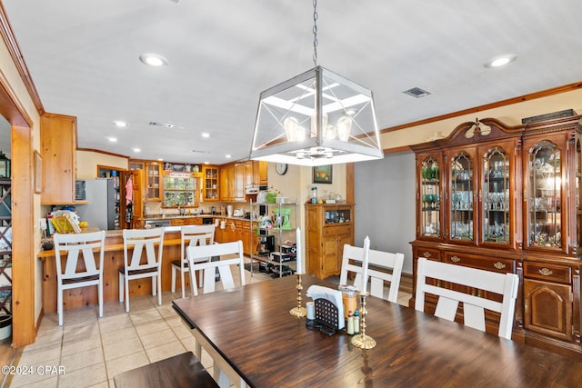 dining room featuring crown molding and light tile patterned flooring