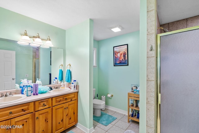 bathroom featuring tile patterned floors, vanity, toilet, and walk in shower