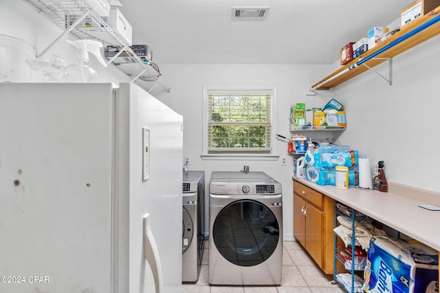 washroom featuring light tile patterned flooring and washing machine and clothes dryer