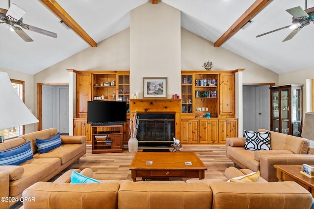 living room featuring lofted ceiling with beams and light hardwood / wood-style floors