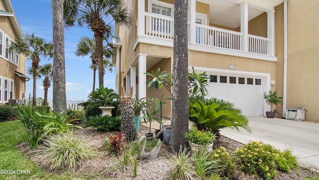 view of side of property featuring a balcony and a garage