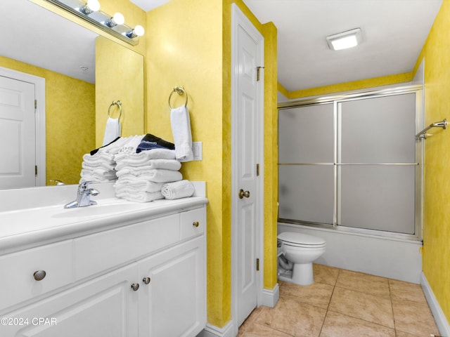 full bathroom with tile patterned flooring, toilet, combined bath / shower with glass door, and vanity