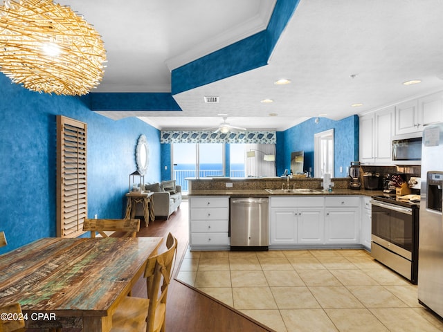 kitchen featuring white cabinets, a water view, sink, and appliances with stainless steel finishes