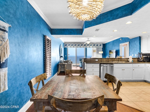 dining space featuring ceiling fan with notable chandelier, a water view, sink, ornamental molding, and light tile patterned flooring