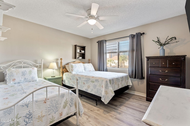 bedroom with a textured ceiling, ceiling fan, and light hardwood / wood-style flooring