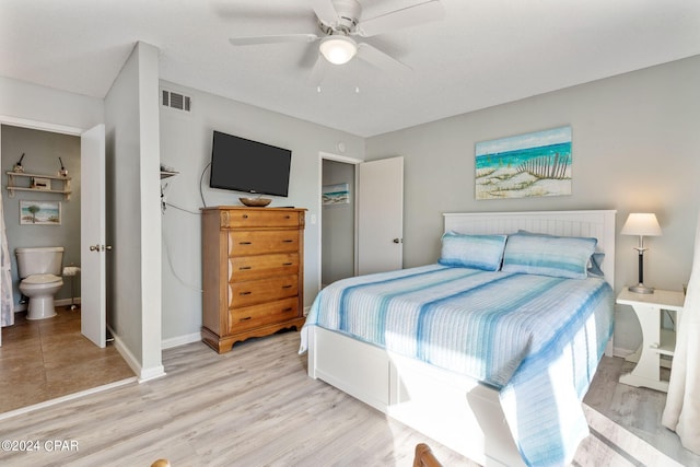 bedroom featuring ensuite bathroom, ceiling fan, light wood-type flooring, and a closet