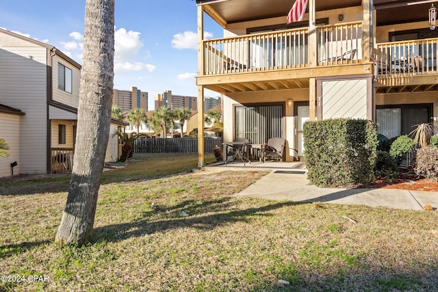 view of yard featuring a balcony and a patio